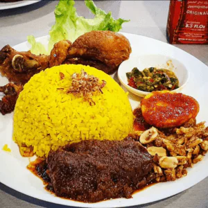 Nasi Kuning Komplit (Tumeric Rice with Fried Chicken, Marinated Beef, Anchovy/Tempeh mix and egg topped with Chilli Sauce)